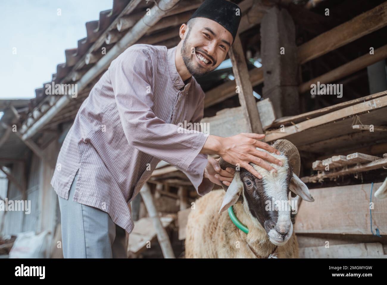 un homme musulman debout avec le sourire et qui a bougé la tête de la chèvre Banque D'Images