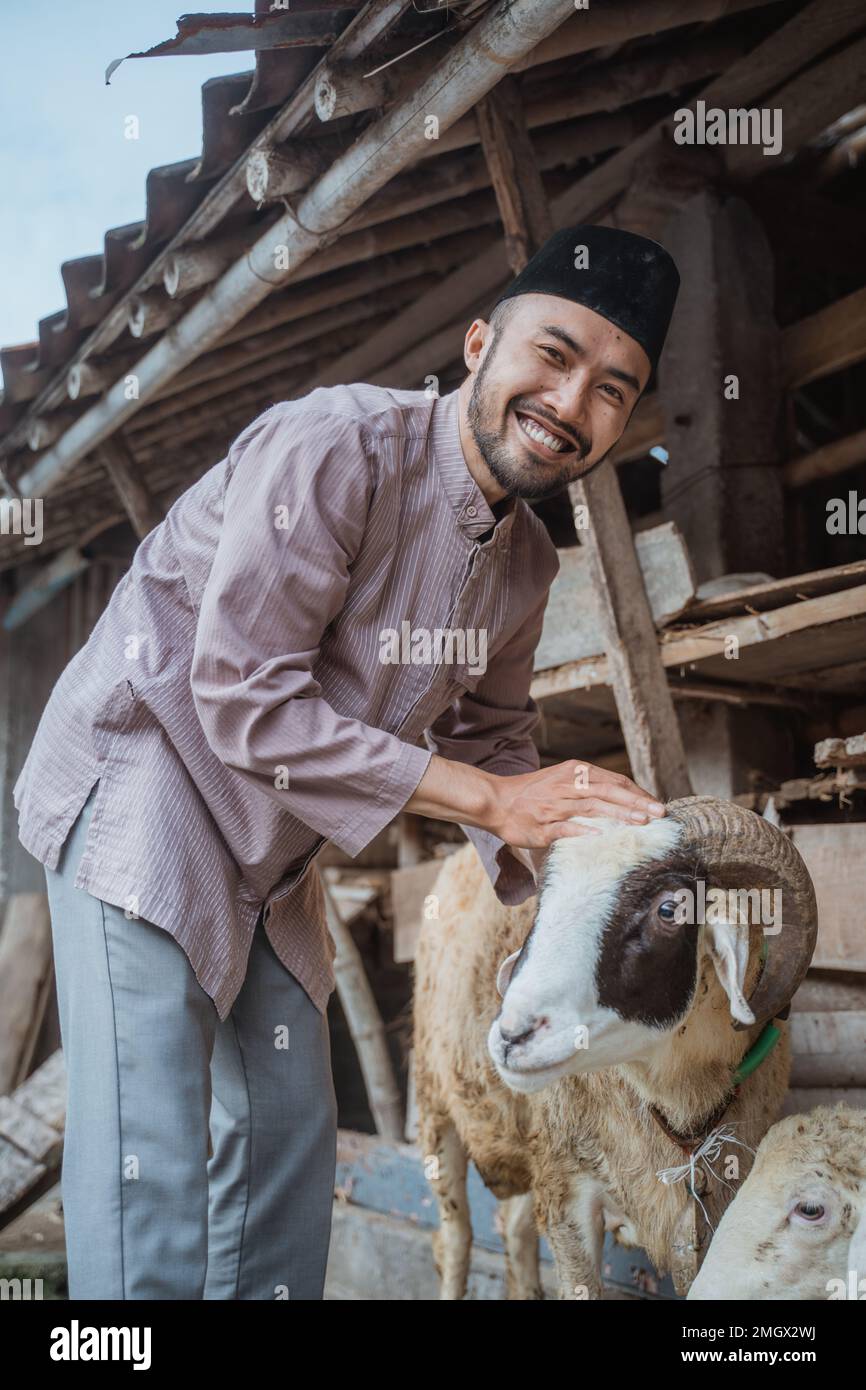 un musulman debout devant l'écurie de la chèvre Banque D'Images
