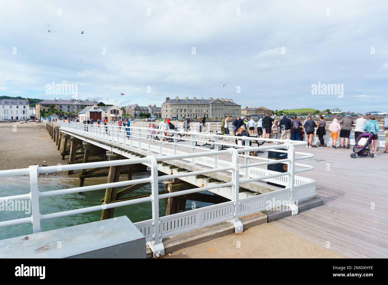 Touristes et visiteurs appréciant un après-midi d'été sur la jetée de Beaumaris une attraction touristique populaire de bord de mer sur l'île d'Anglesey pays de Galles Banque D'Images