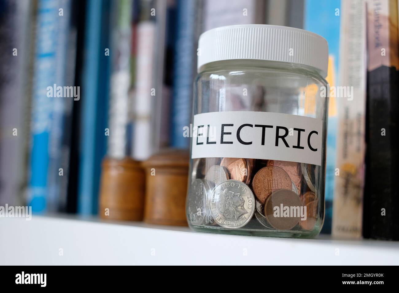 économiser de l'argent dans un pot en verre pour payer la facture d'électricité Banque D'Images