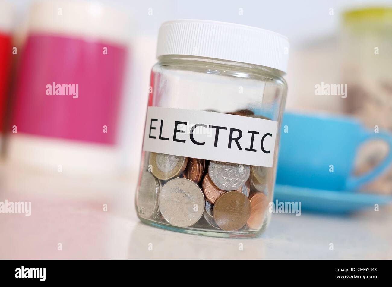 économiser de l'argent dans un pot en verre pour payer la facture d'électricité Banque D'Images