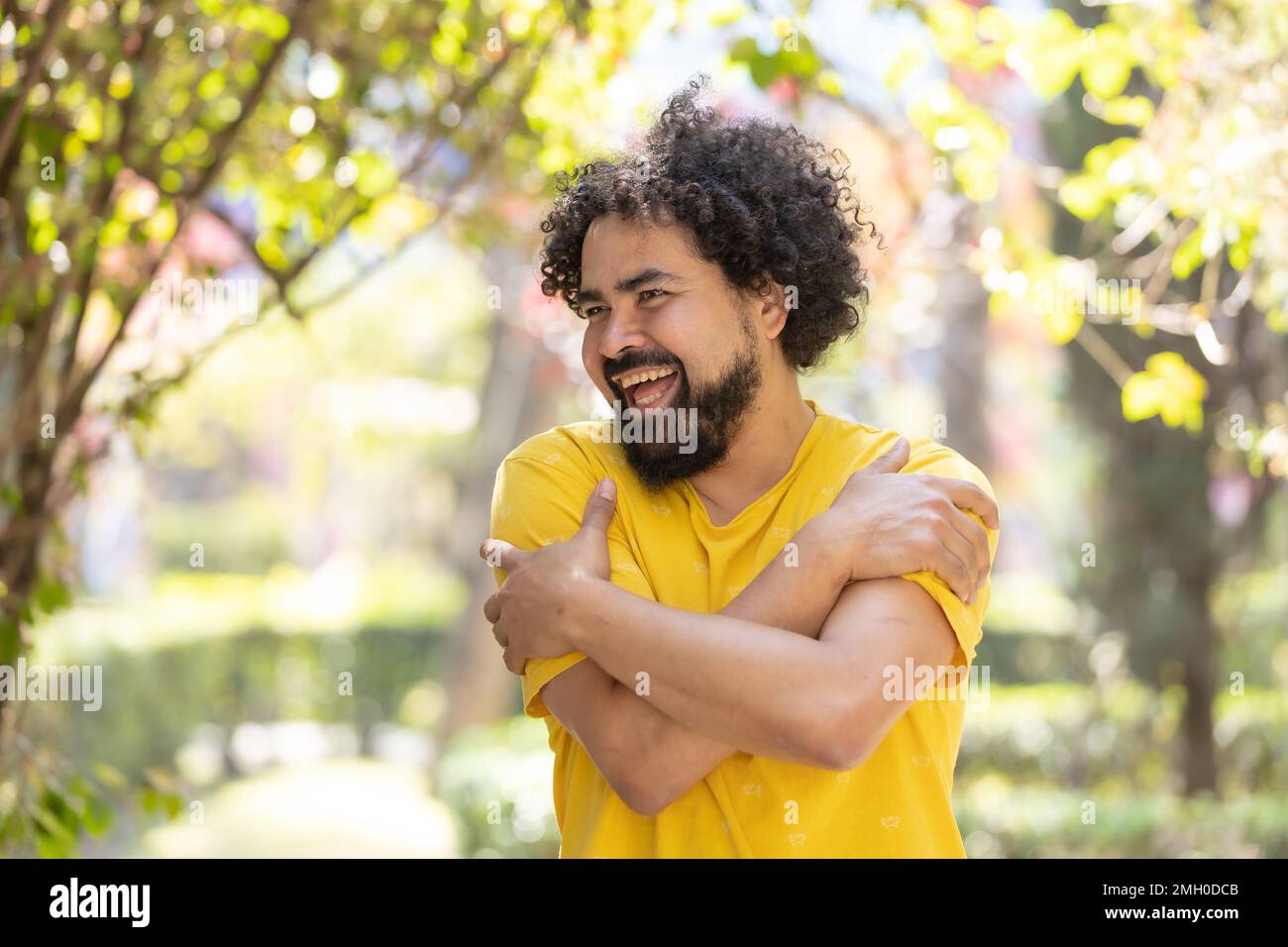 Jeune homme mexicain avec la barbe et afro se embrassant, concept d'amour de soi Banque D'Images