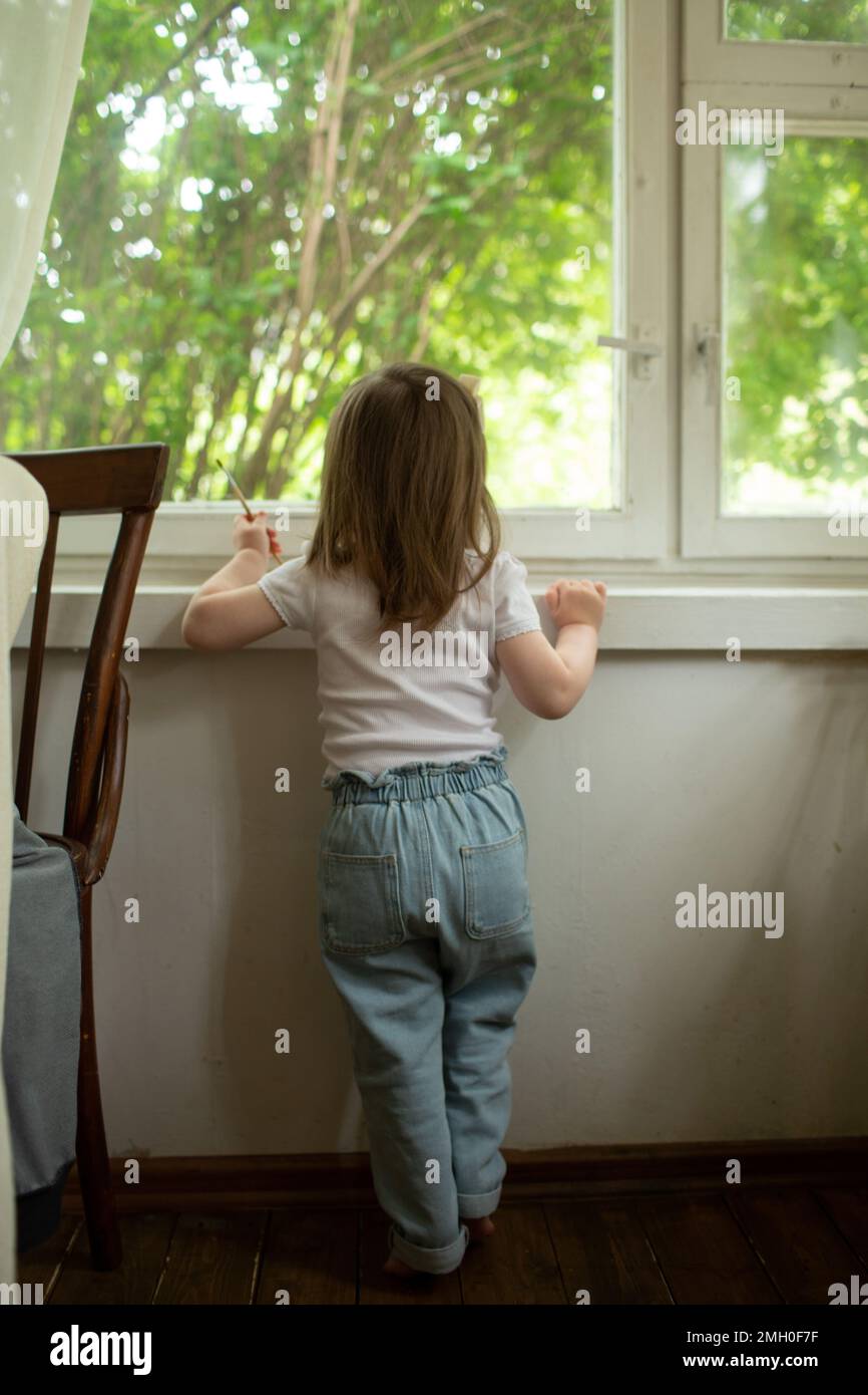 Une petite fille regarde la fenêtre Banque D'Images