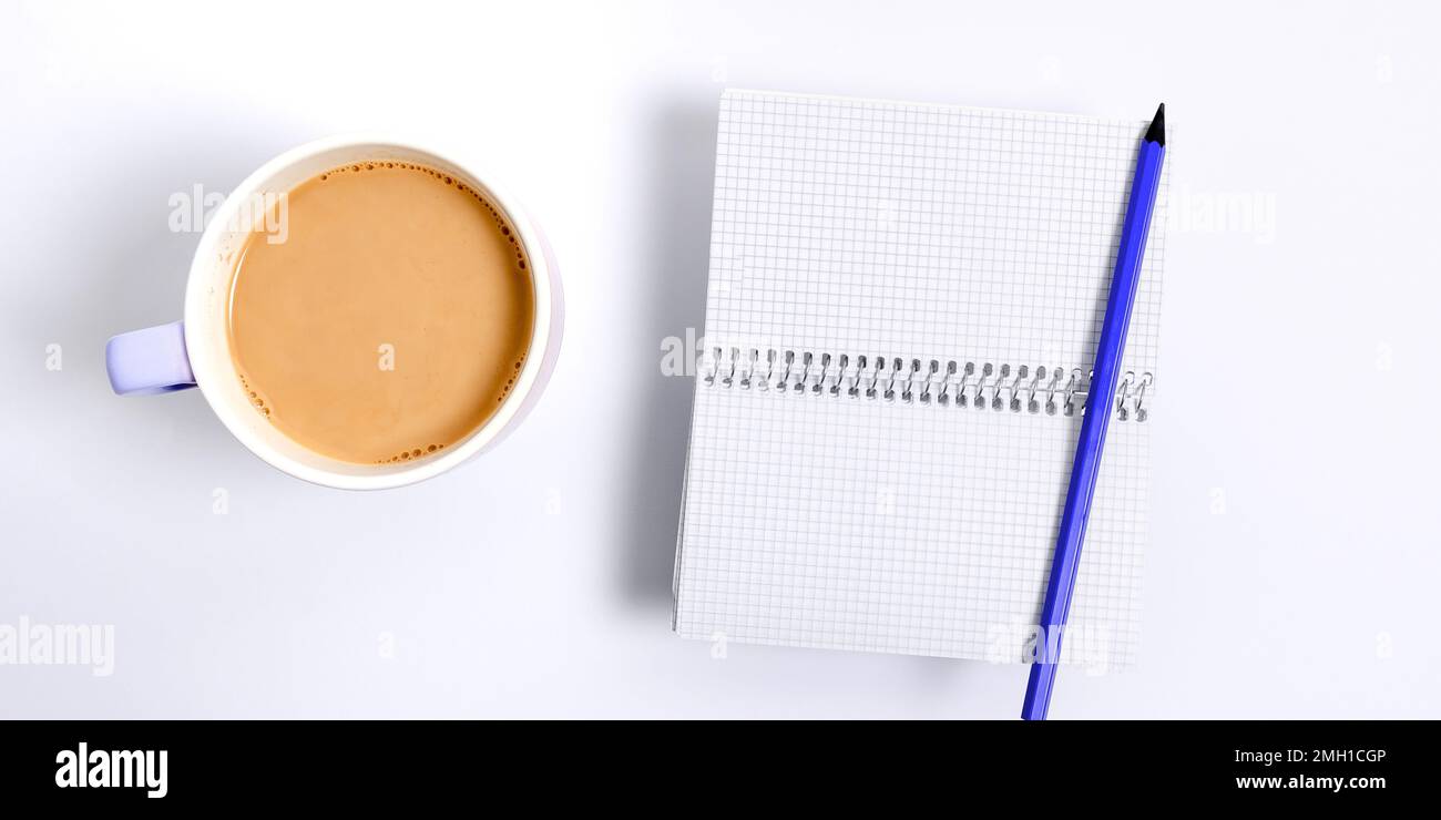 Une tasse de café se tient sur le bureau. Une importante infraction écrite sur papier. Différentes fournitures de bureau, crayons, stylos, Marckers. Clavier de l'ordinateur. Texte activé Banque D'Images