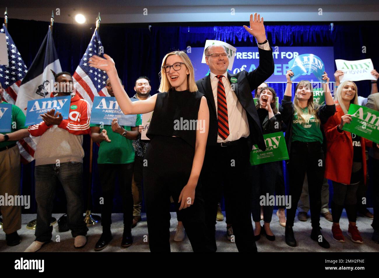 John Bessler, husband of Democratic presidential candidate Sen. Amy Klobuchar, D-Minn., center right, and daughter Abigail Klobuchar Bessler, center left, wave to supporters at her caucus night campaign rally in Des Moines, Iowa, Monday, Feb. 3, 2020. (AP Photo/Nati Harnik) Banque D'Images