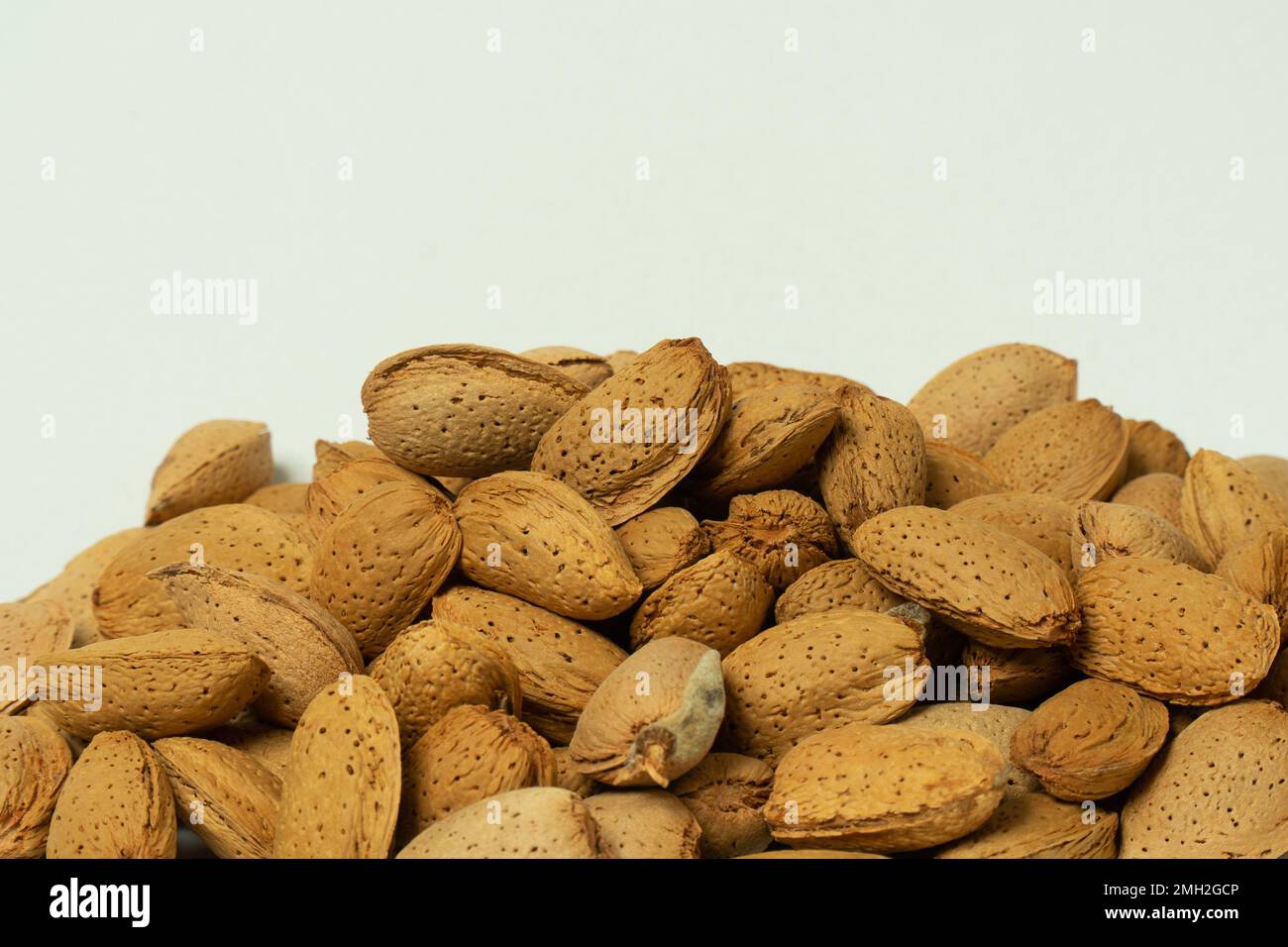 Amandes entières en coquille sur fond blanc. Banque D'Images