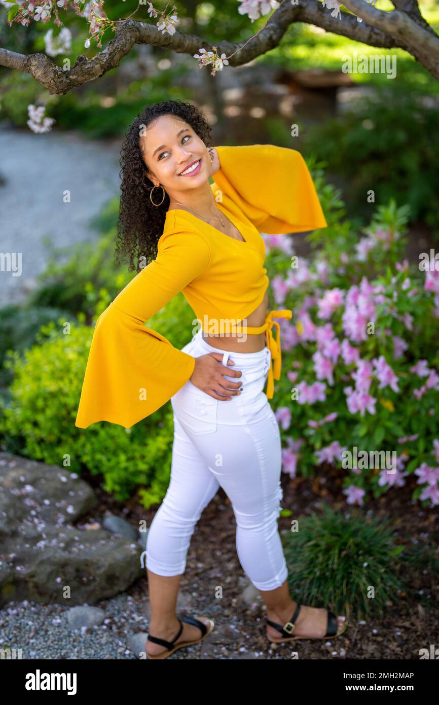 Down angle Portrait de la jeune femme afro-américaine heureuse dans un jardin de style japonais en pleine floraison au printemps Banque D'Images