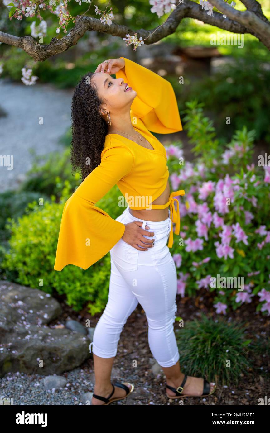 Down angle Portrait de la jeune femme afro-américaine heureuse dans un jardin de style japonais en pleine floraison au printemps Banque D'Images