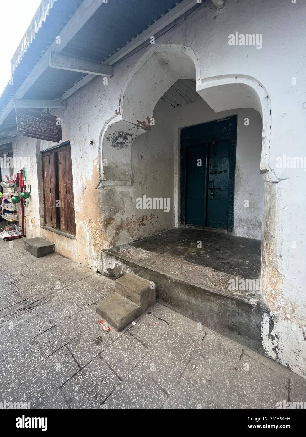 Vieille porte de quartier avec des fissures sur les murs. Ville pauvre de Tanzanie, Zanzibar. Banque D'Images