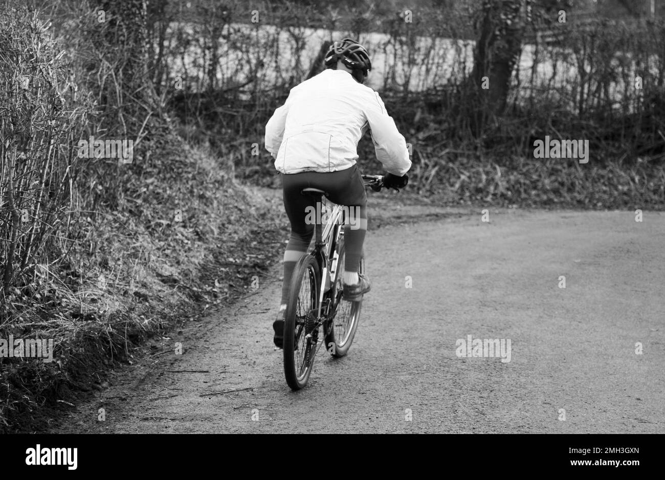 Un cycliste descend la colline par une journée hivernale froide Banque D'Images