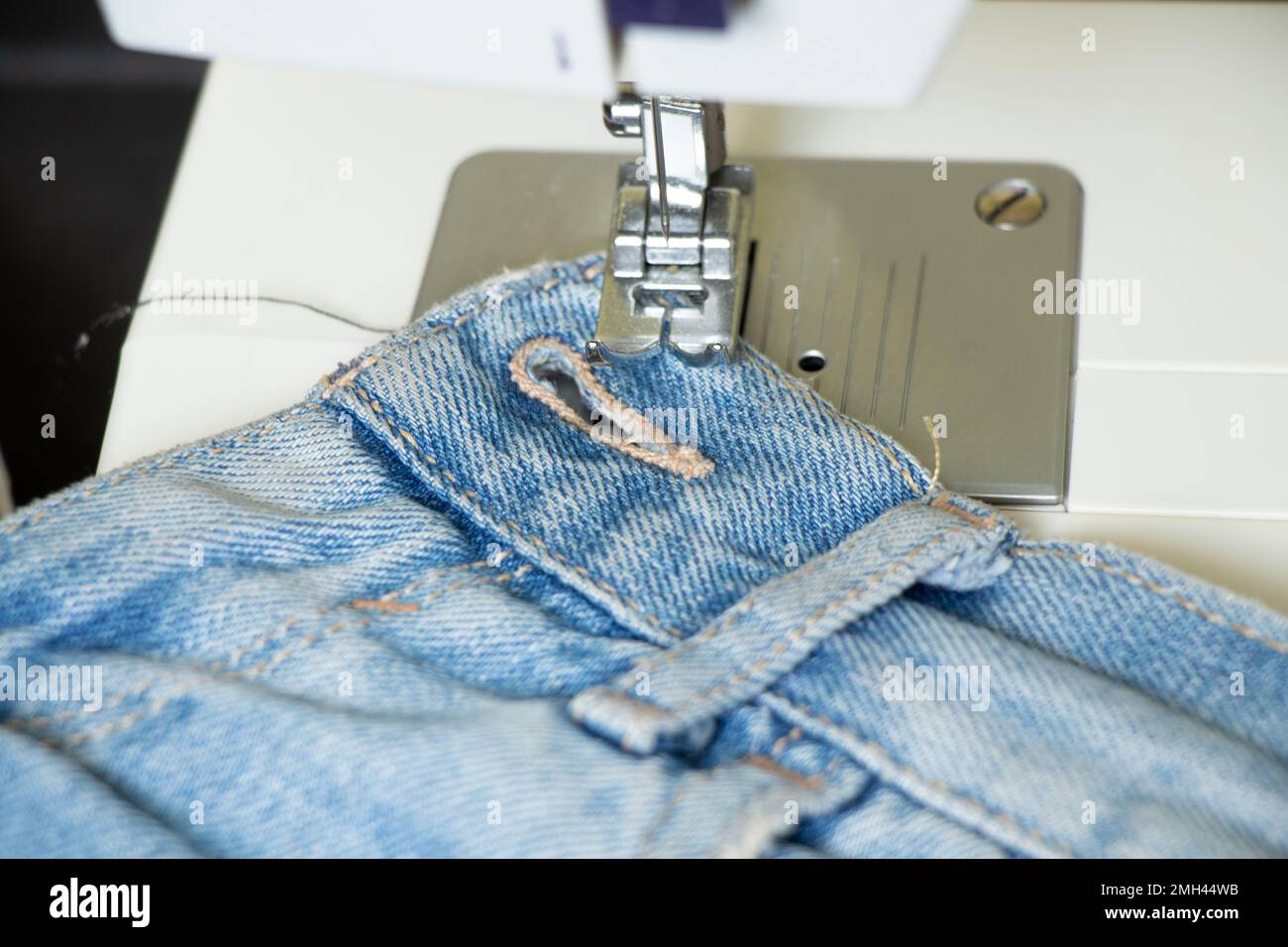 les jeans bleus se trouvent sur une machine à coudre sur la table, les vêtements à coudre, la production de vêtements, la mode Banque D'Images