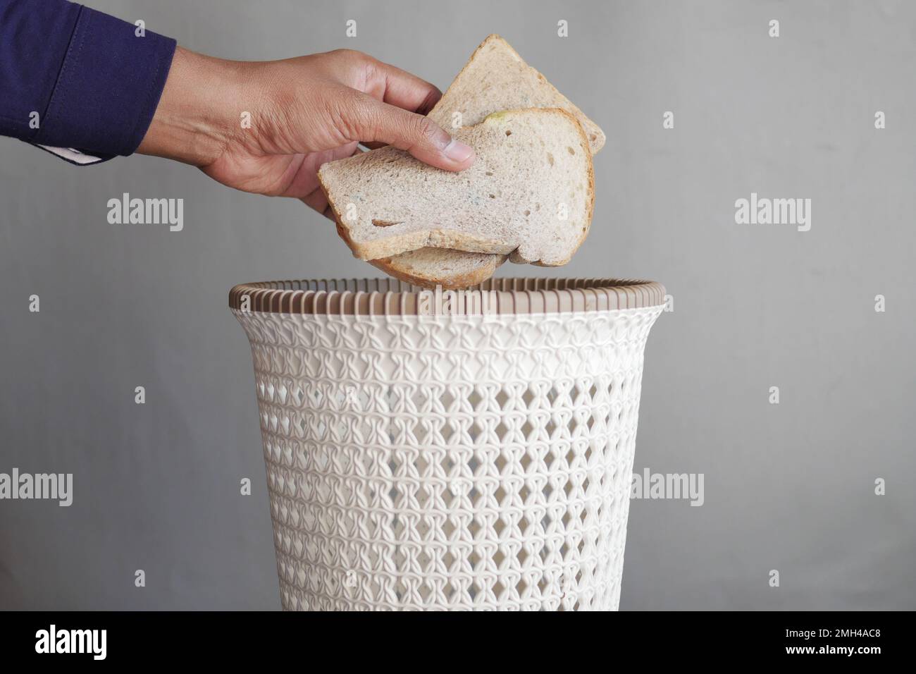 jeter le vieux pain dans une poubelle Banque D'Images
