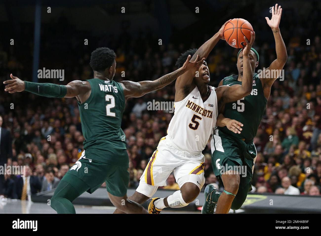 Minnesota's Marcus Carr, center, handles the ball through the defense of Michigan State's Rocket Watts (2) and Cassius Winston, right, during an NCAA college basketball game Sunday, Jan. 26, 2020, in Minneapolis. (AP Photo/Stacy Bengs) Banque D'Images