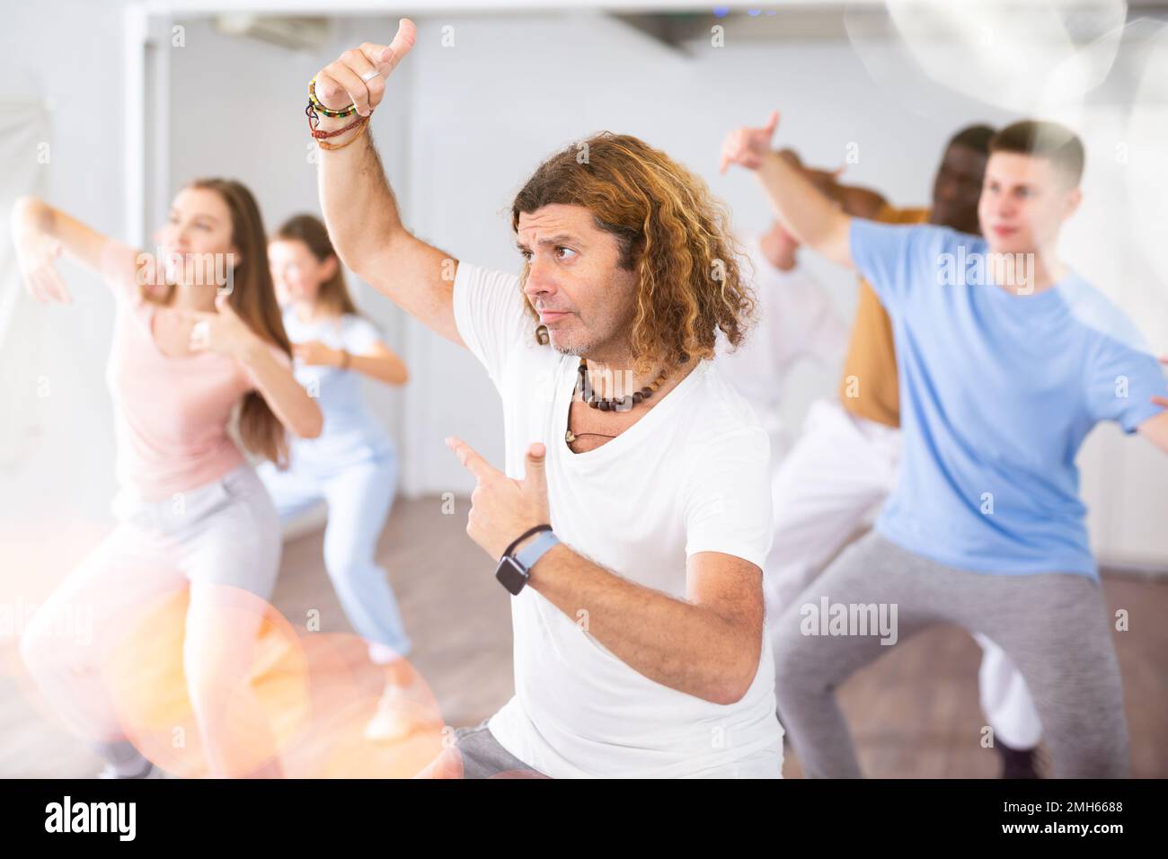 Les femmes et les hommes font de la danse pendant les cours de groupe au centre de conditionnement physique Banque D'Images
