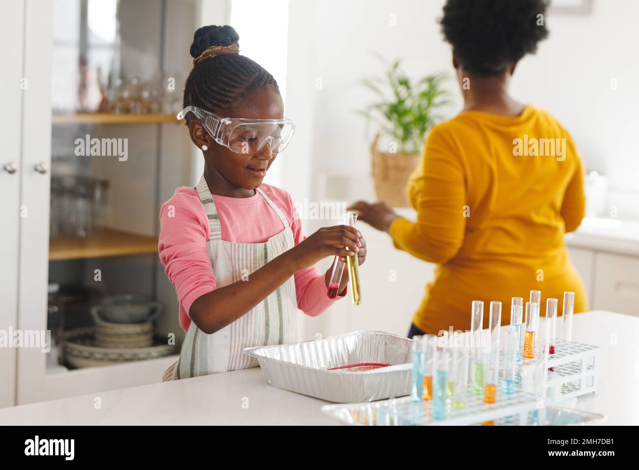 Bonne grand-mère afro-américaine et petite-fille faisant des expériences de chimie dans la cuisine Banque D'Images