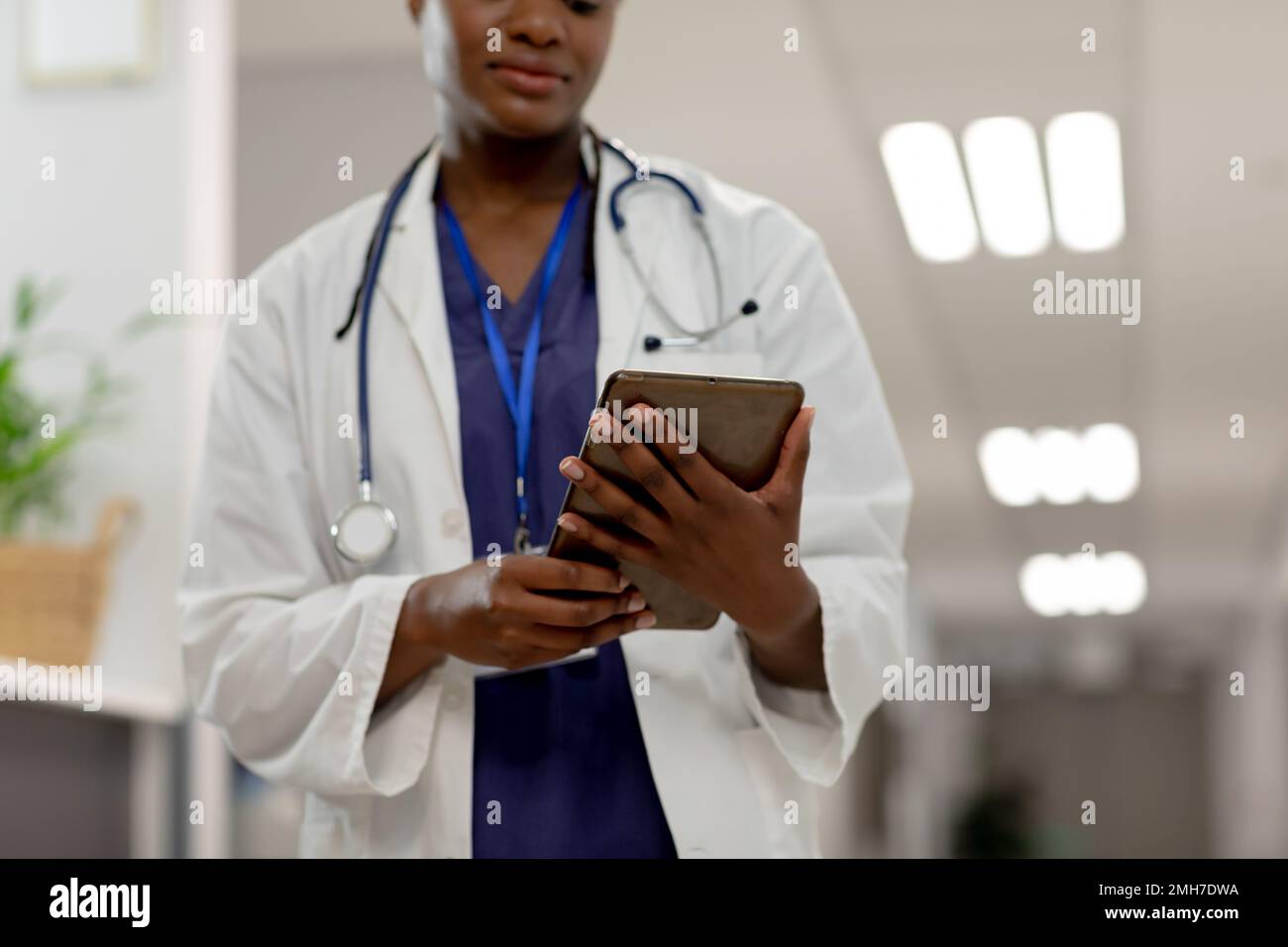 Femme afro-américaine médecin travaillant à l'hôpital, en utilisant une tablette Banque D'Images