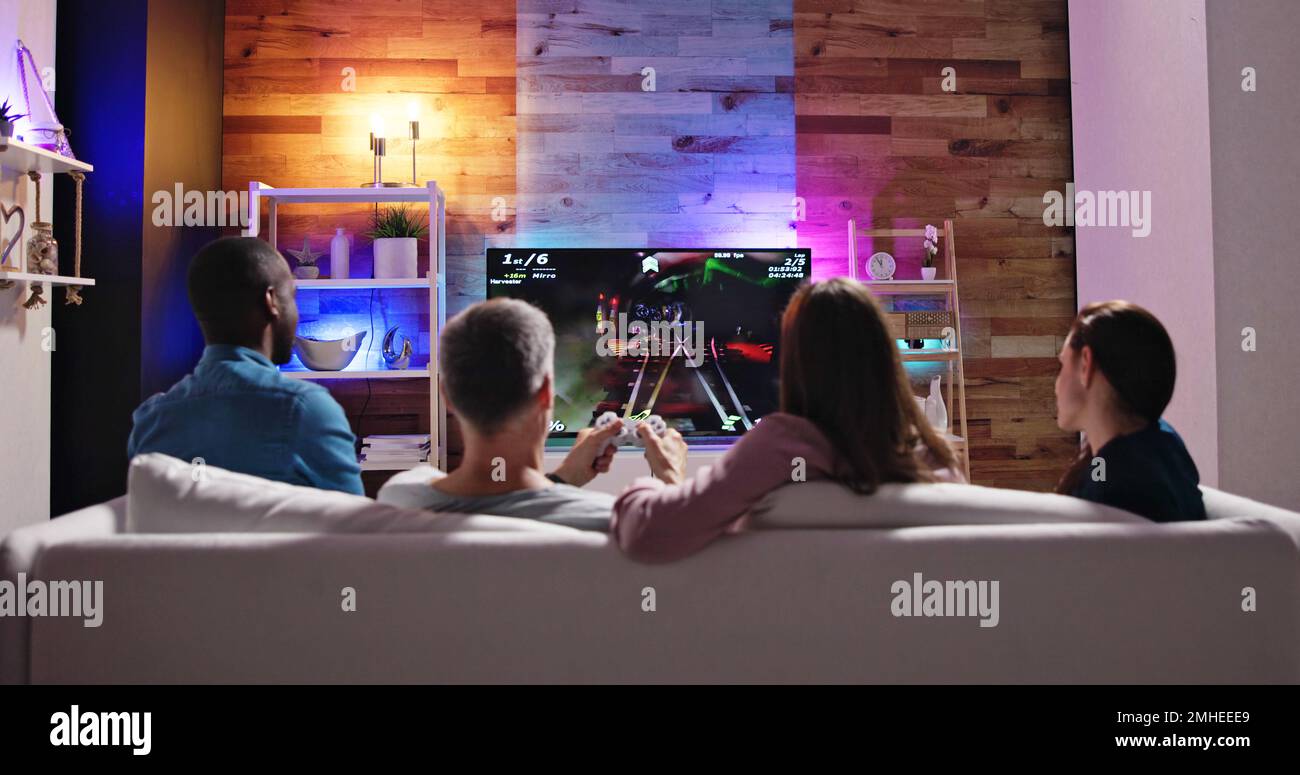 Vue arrière d'une personne jouant à des jeux vidéo à la maison Banque D'Images