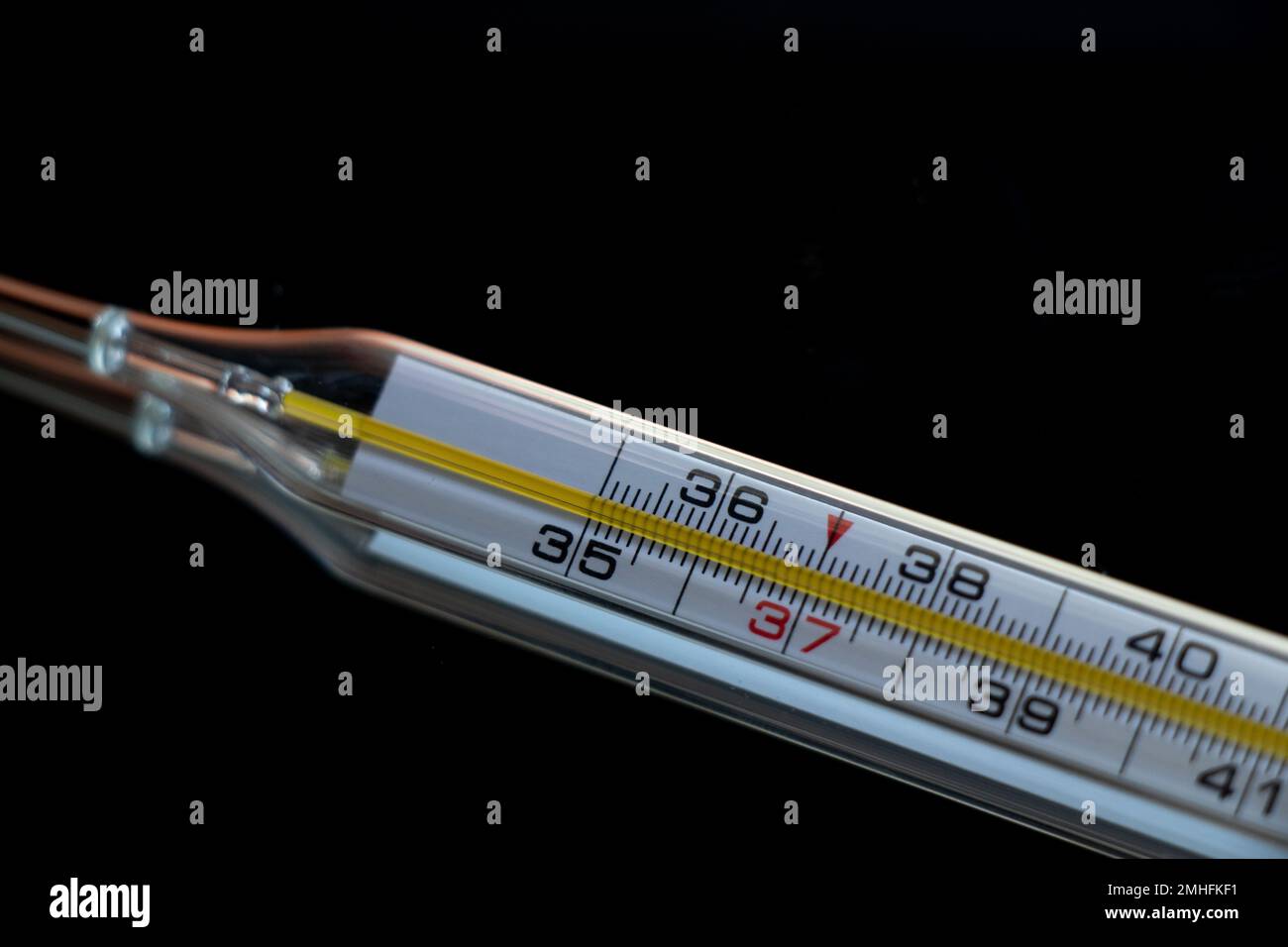 Vieux thermomètre en verre sur fond isolé sombre Banque D'Images