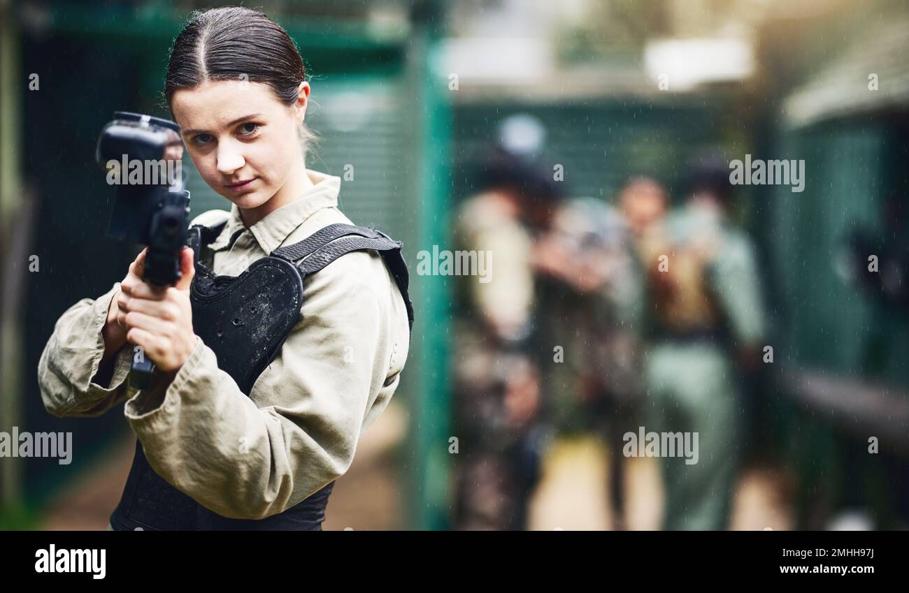 Portrait de paintball, femme et arme à feu visent dans l'arène de jeu, le leadership ou le travail d'équipe sportif en uniforme militaire. Joueur, tireur et fusil de jeu pour Banque D'Images