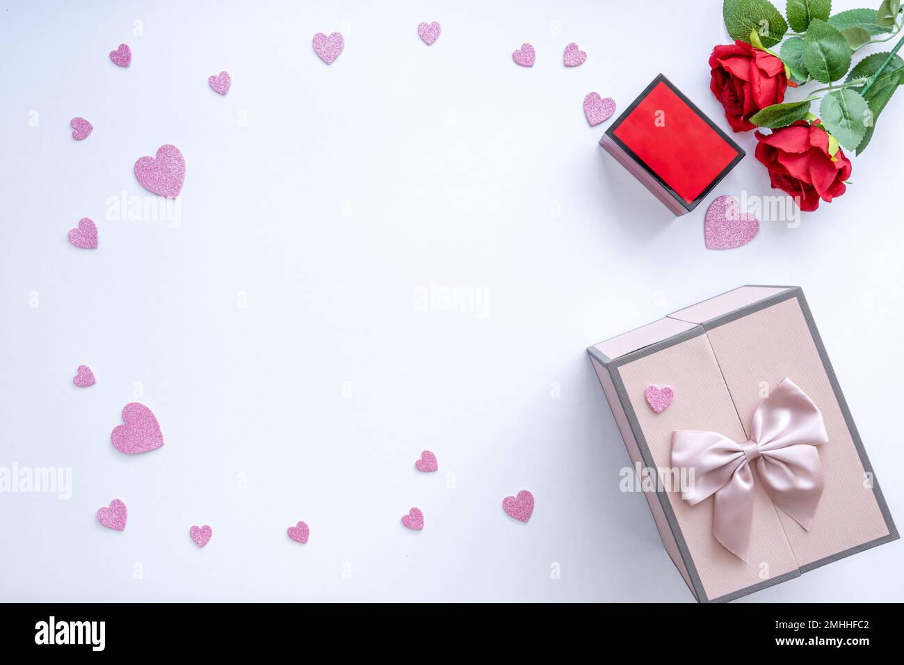 Magnifique fond de la Saint-Valentin avec coeurs rouges, roses, boîte-cadeau et anneaux de proposition sur fond de bannière blanche. Proposition sur le concept de la Saint-Valentin Banque D'Images