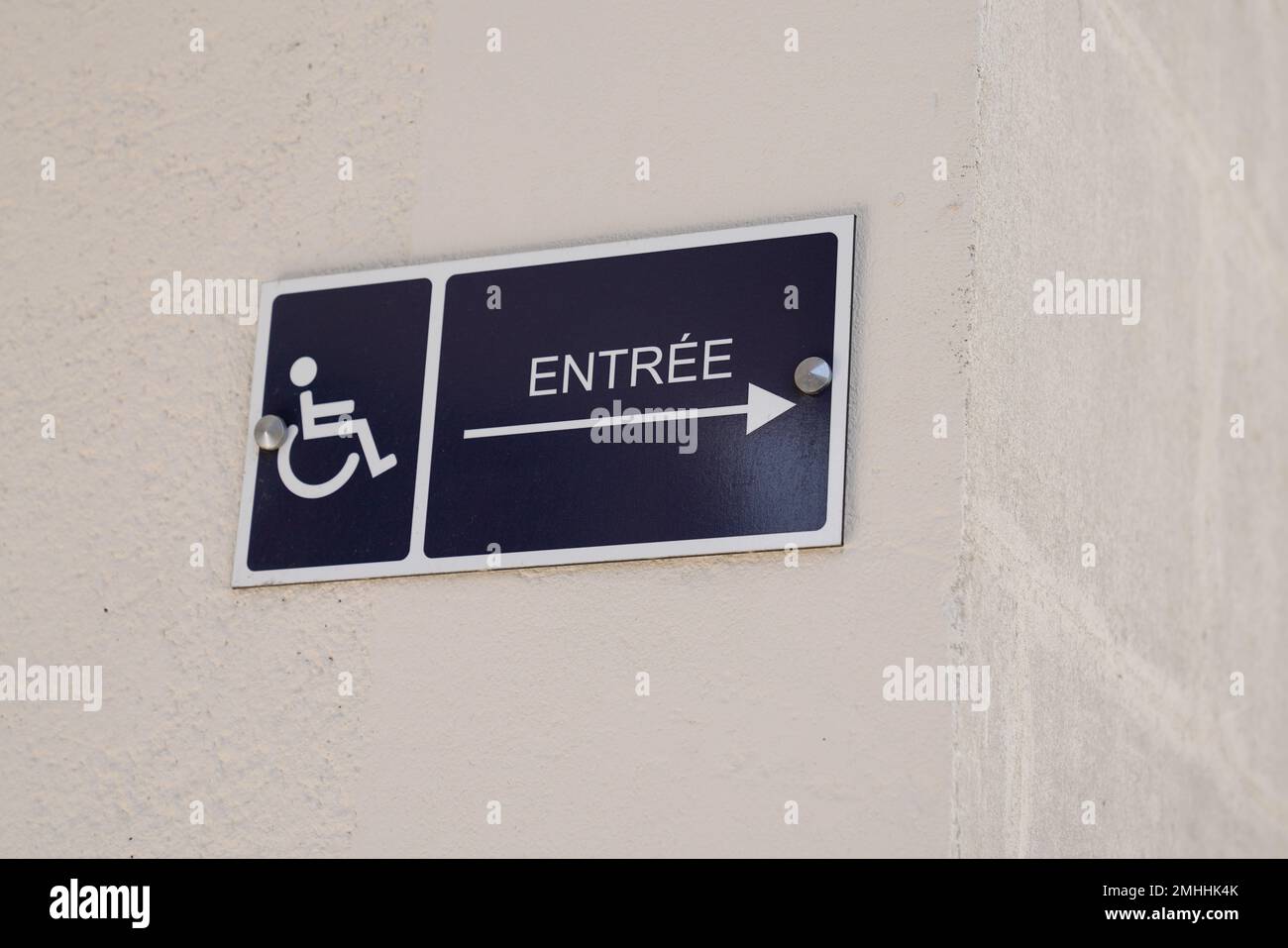 affiche d'entrée de texte en français accessible aux personnes handicapées avec logo handicap fauteuil roulant avec flèche pointant vers le côté Banque D'Images