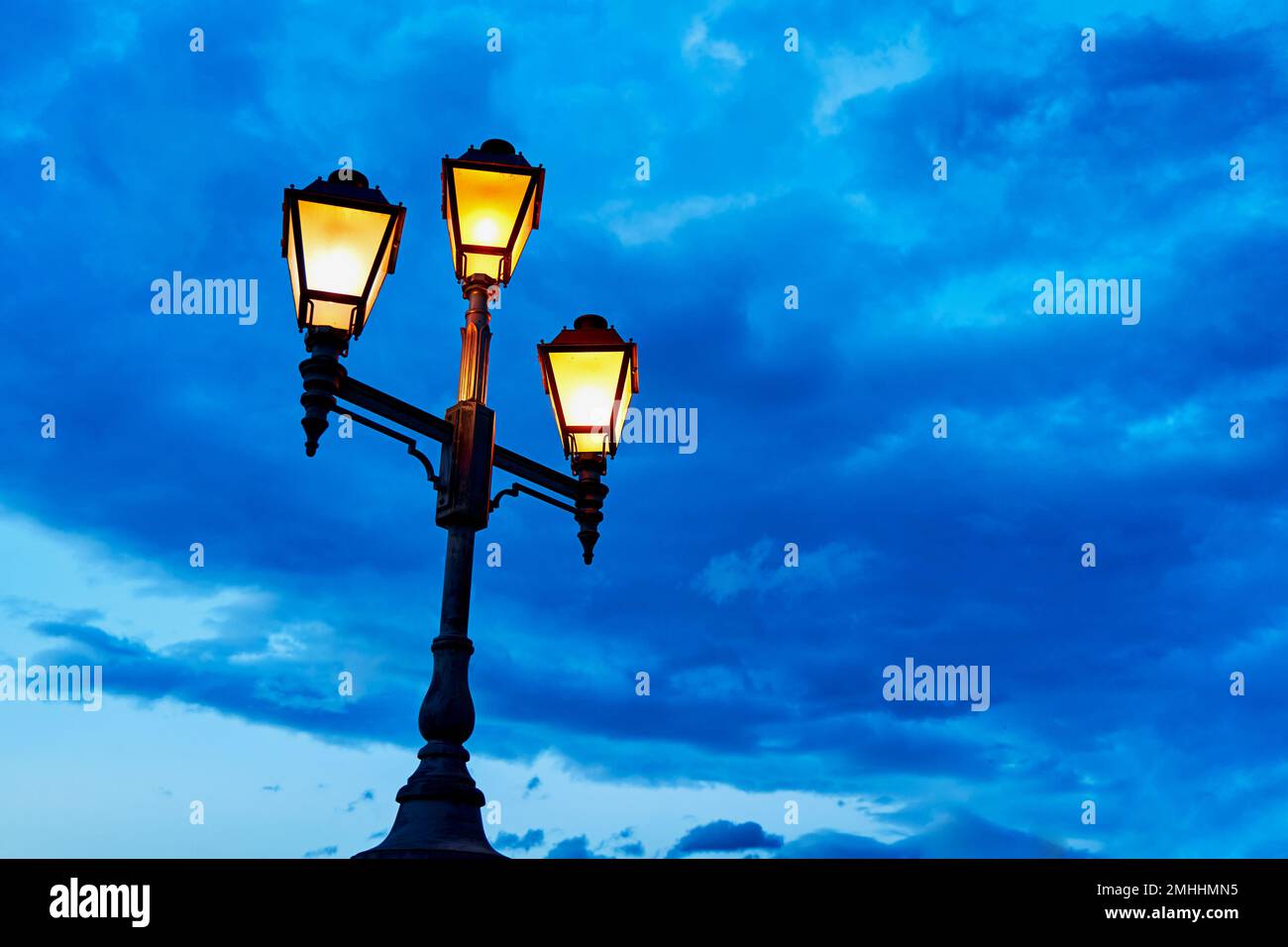 Le lampadaire des lumières de la ville du vieux quartier de la ville. La  lumière chaude de la lanterne contre le ciel bleu froid Photo Stock - Alamy