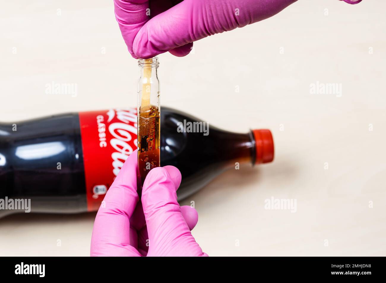 Moscou, Russie - 12 janvier 2023: Mesure du niveau de pH de Coca Cola Classic avec du papier de tournesol. Coca-Cola (Coca-Cola) est une fabrication de boissons gazeuses sans alcool Banque D'Images