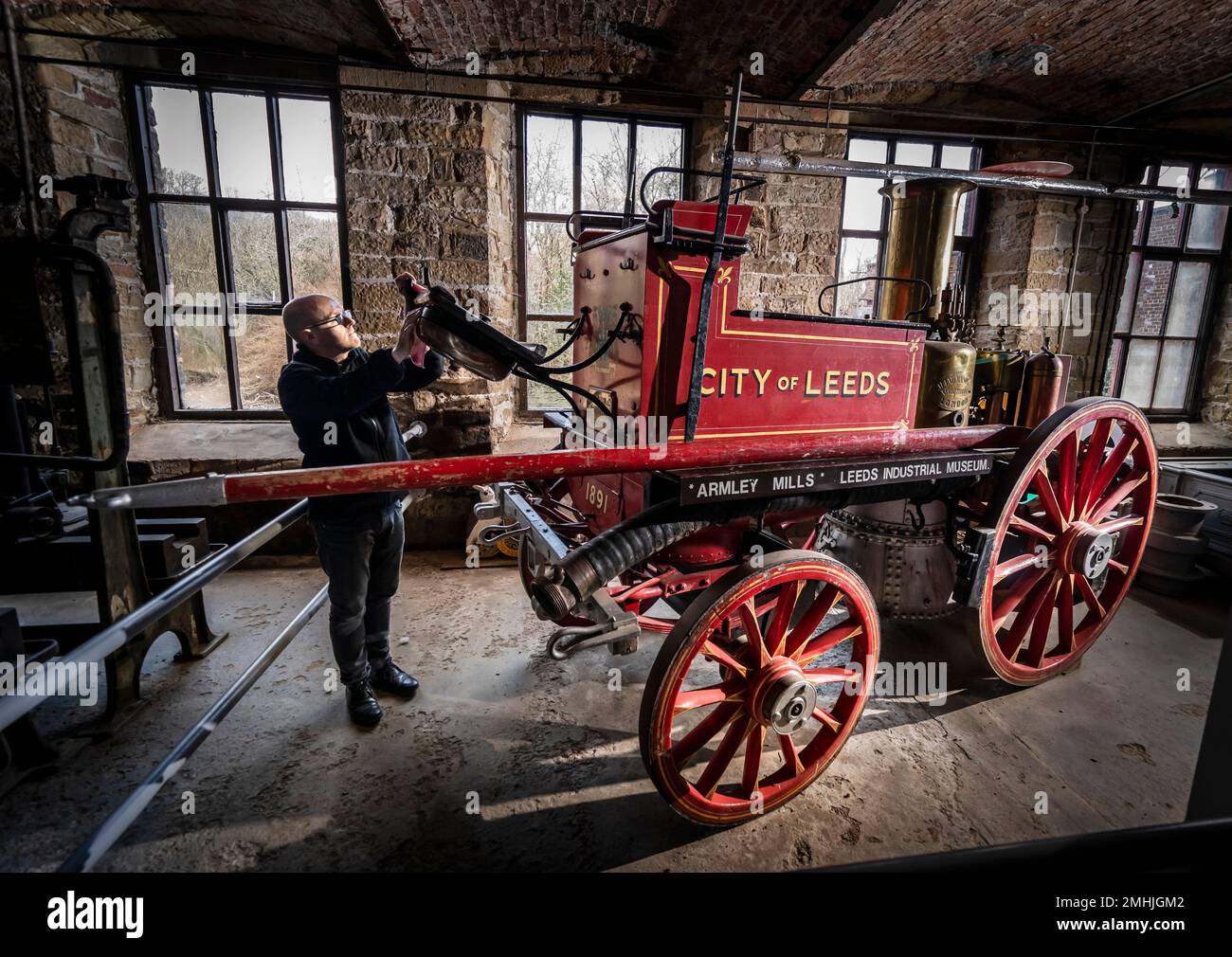 Le conservateur John McGoldrick nettoie un moteur d'incendie de 130 ans au musée industriel de Leeds, dans l'exposition Power House, qui explore l'évolution des moteurs à travers les âges. Autrefois un pilier du service d'incendie, l'impressionnant moteur d'époque a été fabriqué en 1891 par le célèbre Shand Mason and Co Avec une chaudière fabriquée à partir de fer du Yorkshire, le moteur a été entraîné par des chevaux, avec la capacité de lever de la vapeur sur son chemin vers un feu. Date de la photo: Jeudi 26 janvier 2023. Banque D'Images