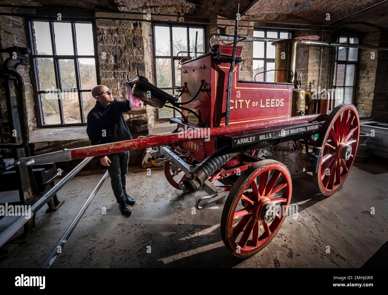 Le conservateur John McGoldrick nettoie un moteur d'incendie de 130 ans au musée industriel de Leeds, dans l'exposition Power House, qui explore l'évolution des moteurs à travers les âges. Autrefois un pilier du service d'incendie, l'impressionnant moteur d'époque a été fabriqué en 1891 par le célèbre Shand Mason and Co Avec une chaudière fabriquée à partir de fer du Yorkshire, le moteur a été entraîné par des chevaux, avec la capacité de lever de la vapeur sur son chemin vers un feu. Date de la photo: Jeudi 26 janvier 2023. Banque D'Images