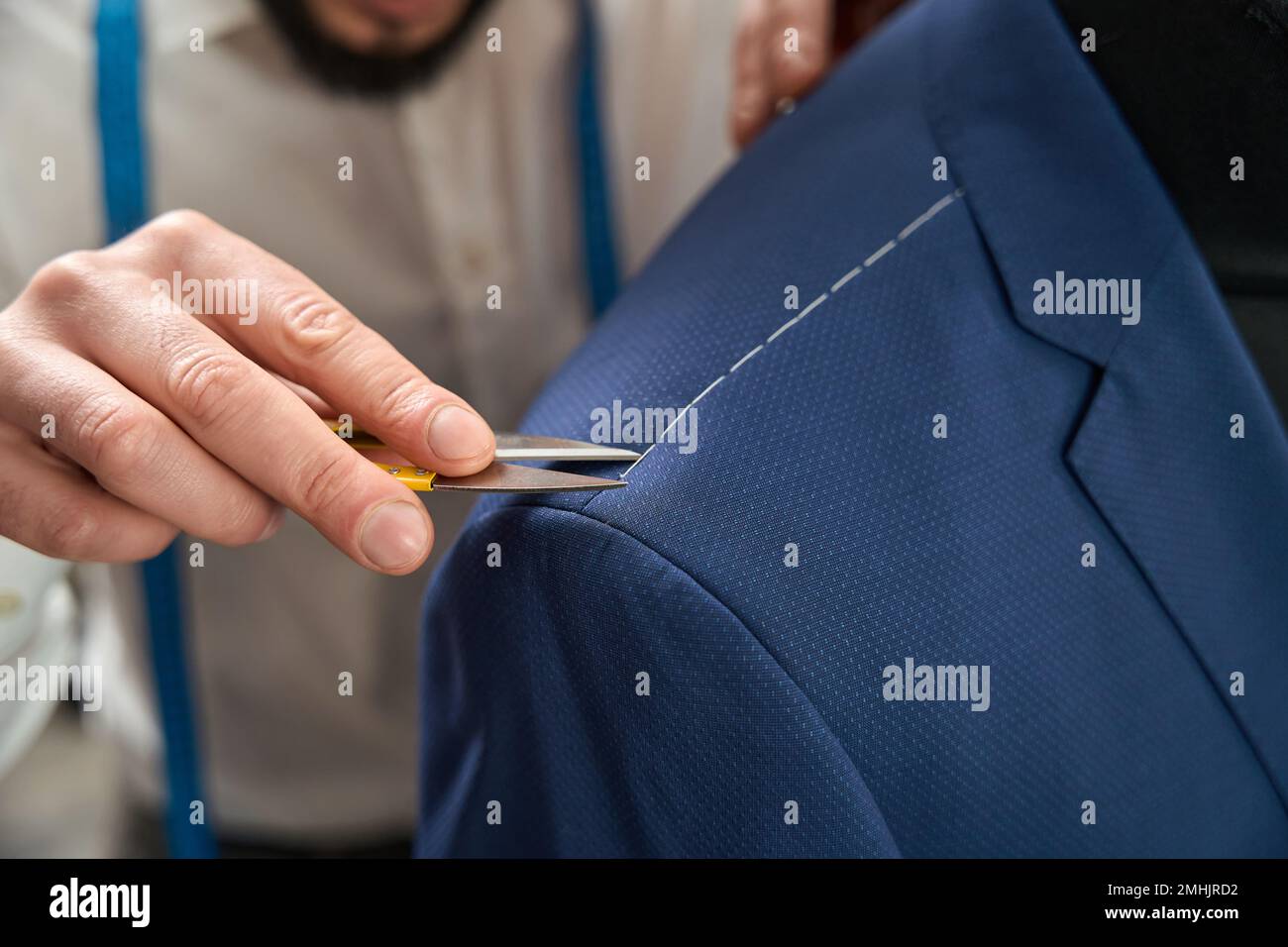 Un tailleur expérimenté élimine les points de suture de l'article de vêtement Banque D'Images