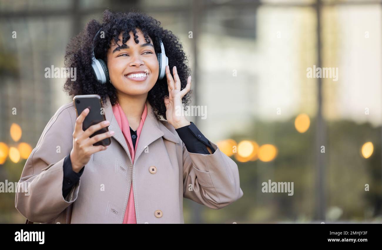 Sourire, femme heureuse ou noire avec de la musique en ville, à la radio ou au podcast sur un casque qui marche dans la rue ou au bureau. Démarrage, employé ou travailleur se déplace sur Banque D'Images