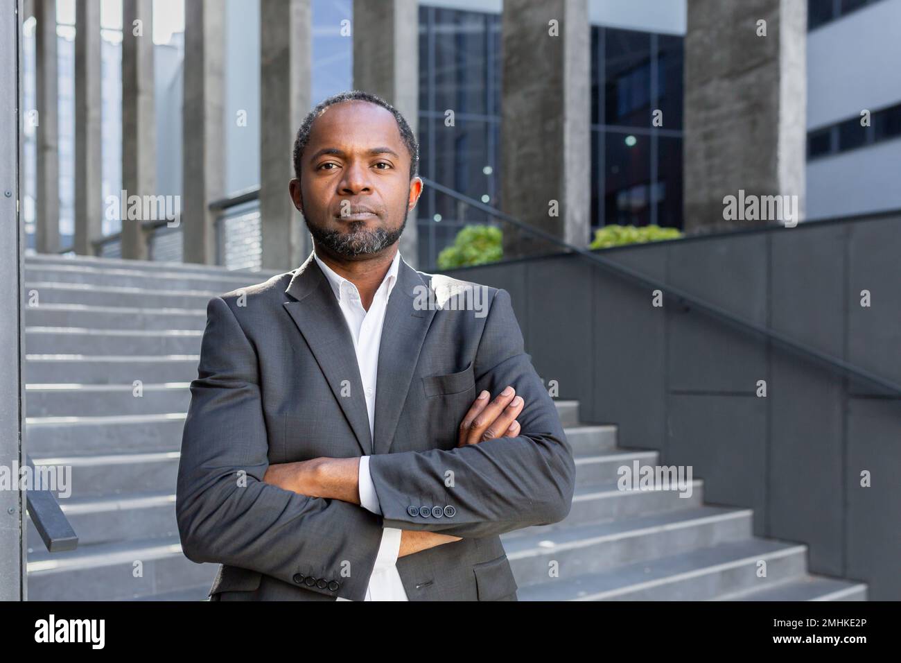Homme d'affaires sérieux avec des armes croisées regardant l'appareil photo, portrait de l'investisseur afro-américain patron à l'extérieur dans le bureau, homme en costume d'affaires. Banque D'Images