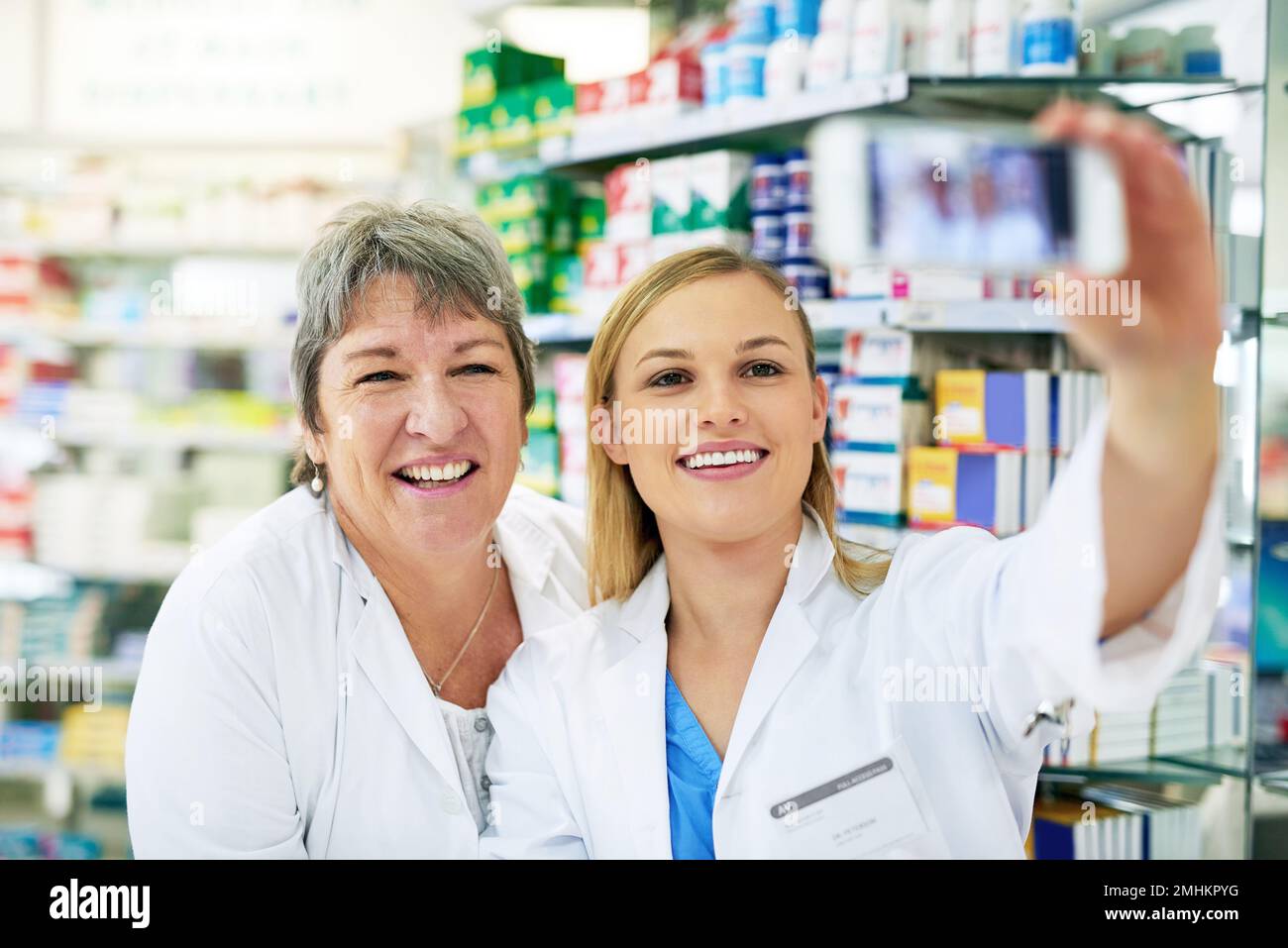 Selfies - la nouvelle façon d'auto-promotion. deux pharmaciens heureux prenant un selfie ensemble dans un chimiste. Banque D'Images