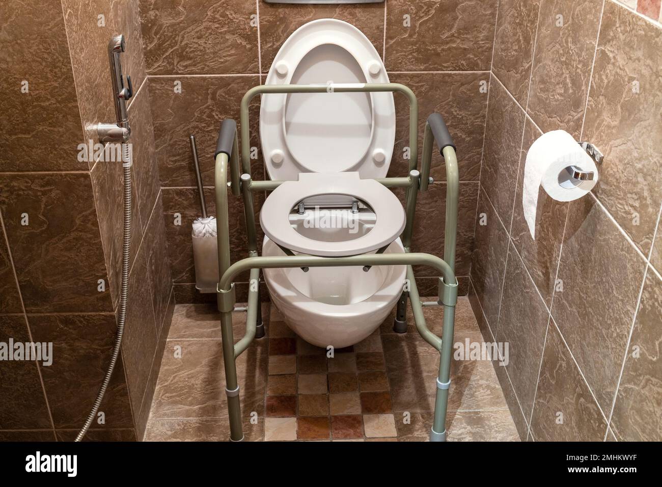 chaise sanitaire pliable installée au-dessus des toilettes ordinaires dans la salle de toilette de la maison Banque D'Images