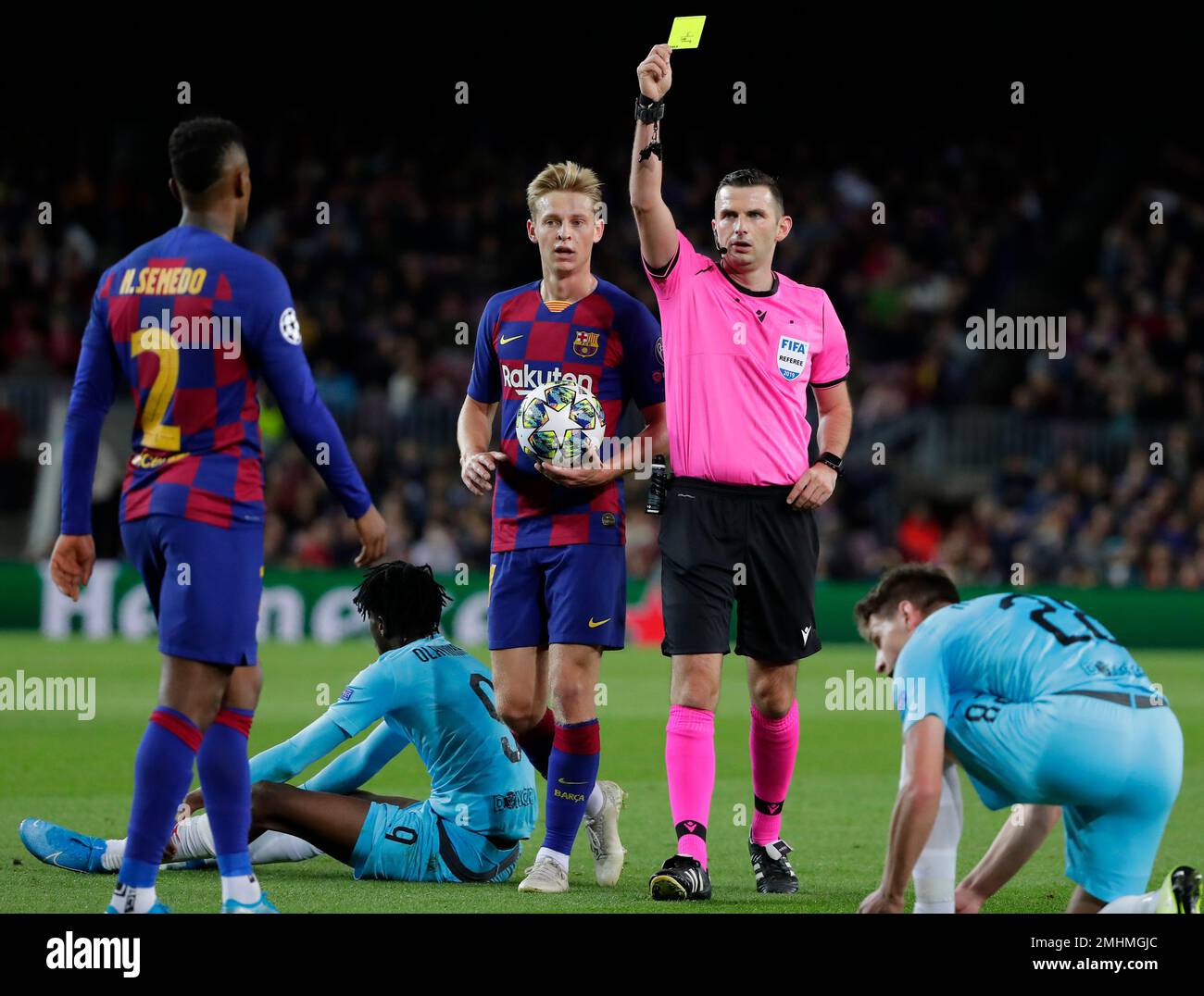 Referee Michael Oliver of England shows a yellow card to Barcelona's Nelson Semedo, left, during a Champions League group F soccer match between Barcelona and Slavia Praha at Camp Nou stadium in Barcelona, Spain, Tuesday, Nov. 5, 2019. (AP Photo/Emilio Morenatti) Banque D'Images