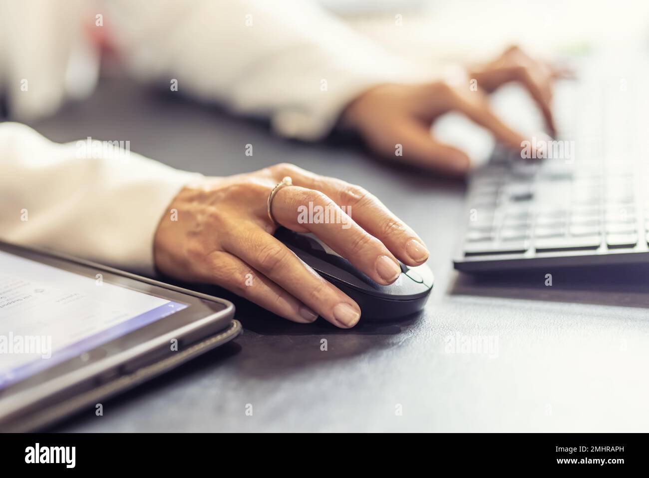 Mains d'une femme d'affaires tenant la souris et le clavier d'ordinateur au bureau. Banque D'Images
