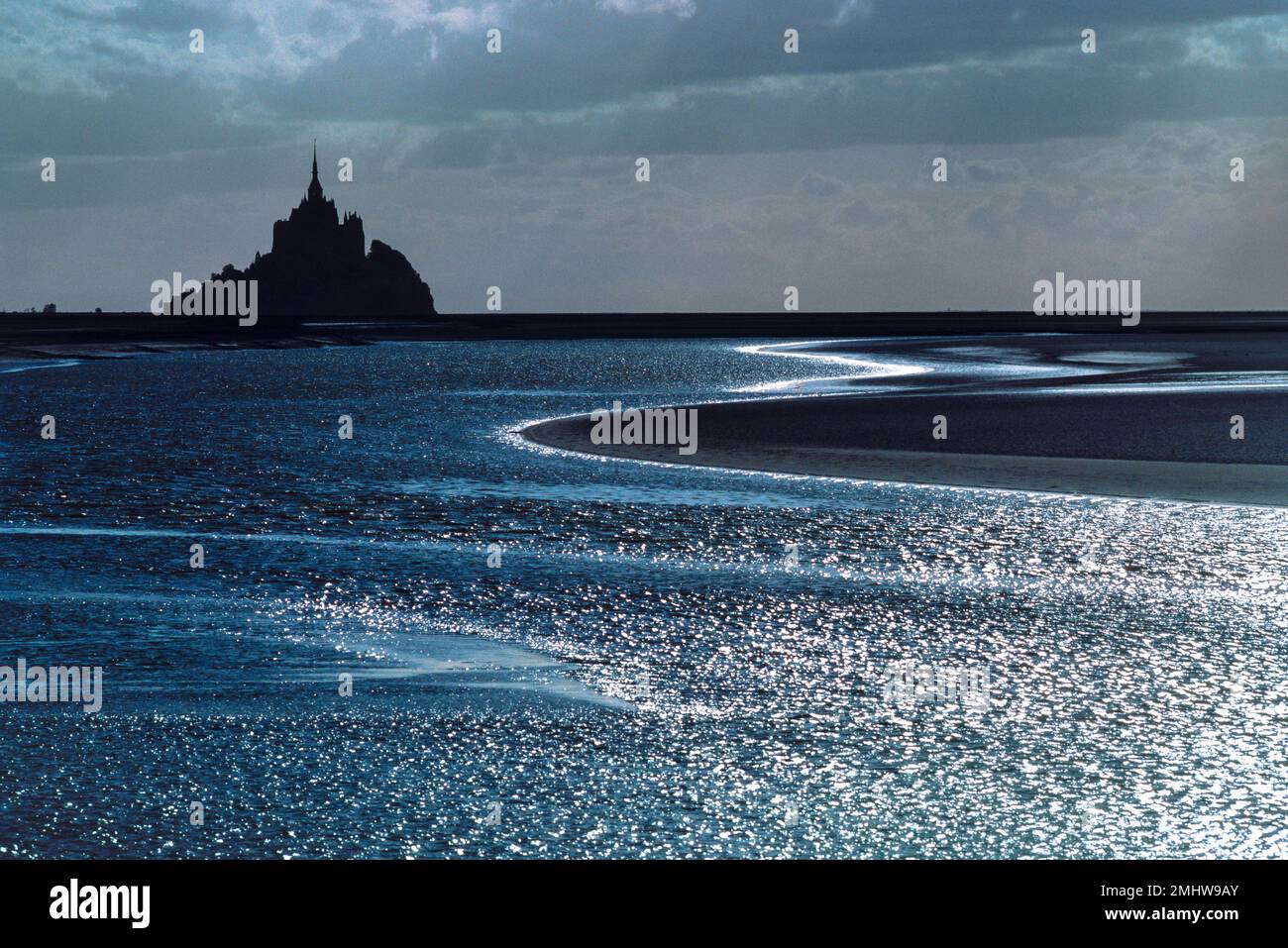 Mont Saint Michel France, vue en soirée du Mont Saint Michel en silhouette entourée d'une plage au clair de lune à marée basse, Normandie, France Banque D'Images