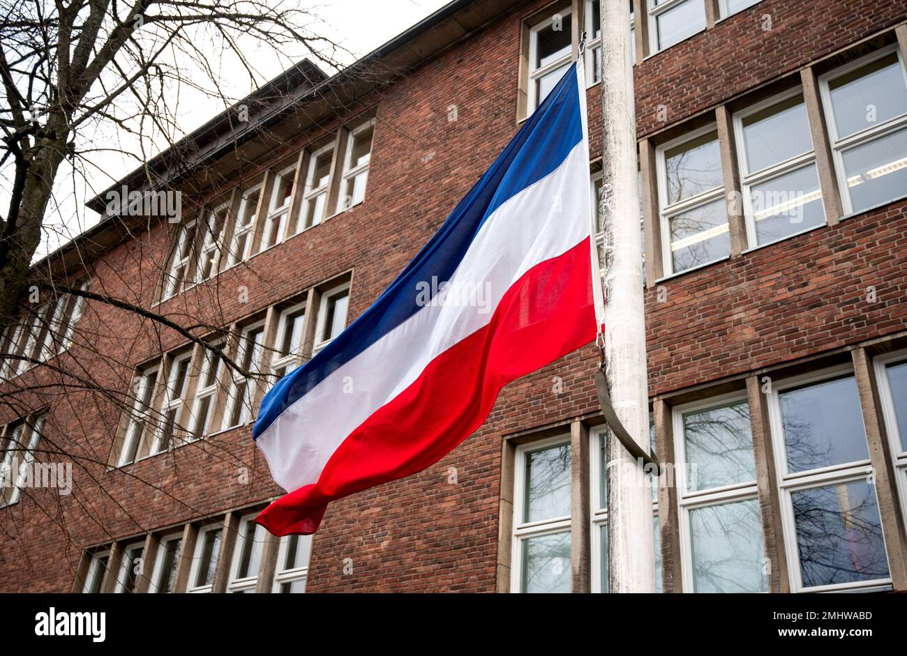27 janvier 2023, Schleswig-Holstein, Neumünster : un drapeau du Schleswig-Holstein vole en Berne devant l'école Walther Lehmuhl. Les victimes d'une attaque au couteau sur un train à Brokstedt sont allées à cette école. Deux jeunes ont été tués et cinq blessés lors de l'attaque au couteau d'un train régional de Kiel à Hambourg le 25 janvier 2023. Photo: Daniel Bockwoldt/dpa Banque D'Images
