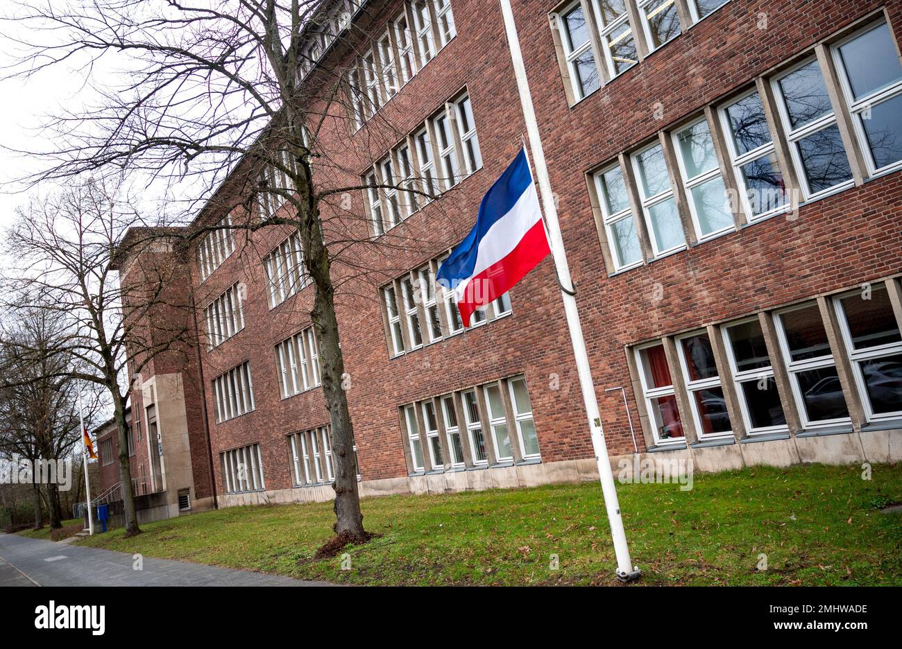 27 janvier 2023, Schleswig-Holstein, Neumünster : un drapeau du Schleswig-Holstein vole en Berne devant l'école Walther Lehmuhl. Les victimes d'une attaque au couteau sur un train à Brokstedt sont allées à cette école. Deux jeunes ont été tués et cinq blessés lors de l'attaque au couteau d'un train régional de Kiel à Hambourg le 25 janvier 2023. Photo: Daniel Bockwoldt/dpa Banque D'Images