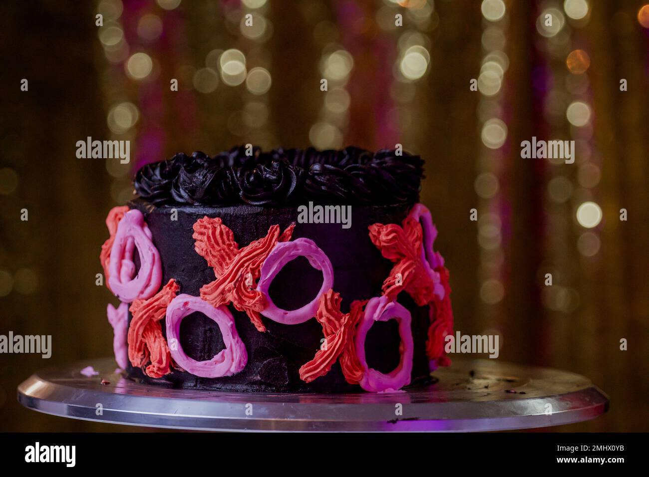 Femme dans sa cuisine de pâtisserie et de décoration d'un gâteau de la Saint-Valentin Banque D'Images