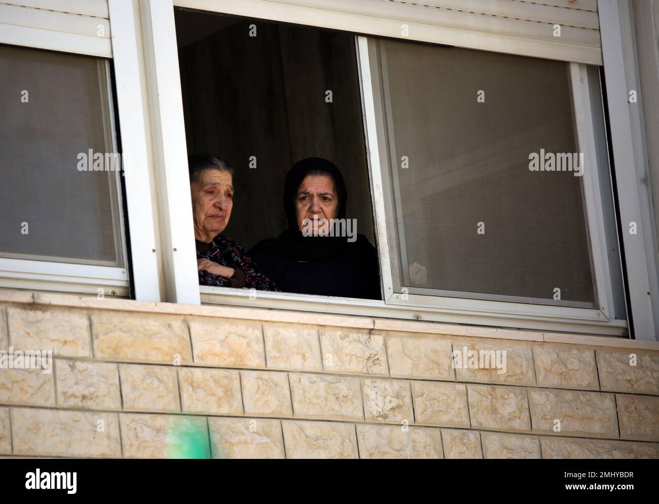 Al RAM, Palestine. 27th janvier 2023. Des parents qui regardent par une fenêtre pleurent pendant la cérémonie funéraire du palestinien Yusuf Yahya Abdulkerim Muhsin (22), qui a été lourdement blessé par des coups de feu israéliens et a perdu la vie à l'hôpital, dans la ville d'Al-RAM à Jérusalem-est. Le palestinien Youssef Yahya Abdel Karim Mohsen (22 ans) a été gravement blessé par des tirs israéliens et a perdu la vie à l'hôpital de la ville d'Al-RAM à Jérusalem-est. Crédit : SOPA Images Limited/Alamy Live News Banque D'Images