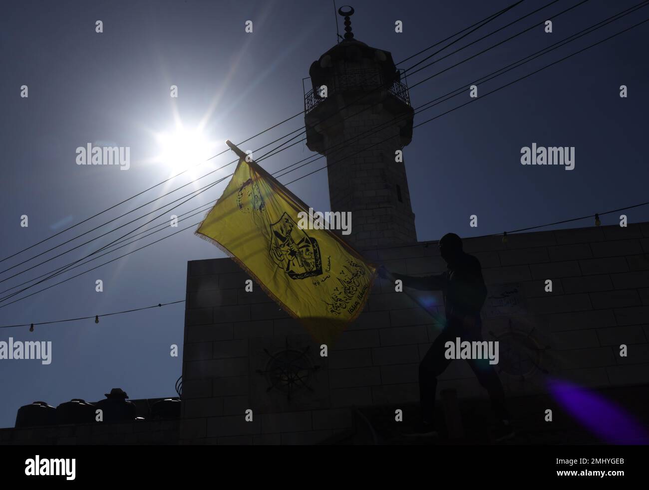 Al RAM, Palestine. 27th janvier 2023. Un homme agite un drapeau du mouvement du Fatah lors des funérailles du palestinien Youssef Yahya Abdul Karim Mohsen (22 ans), qui a été gravement blessé par les balles de l'occupation israélienne et a perdu la vie à l'hôpital de la ville d'Al-RAM à Jérusalem-est. Le palestinien Youssef Yahya Abdel Karim Mohsen (22 ans) a été gravement blessé par des tirs israéliens et a perdu la vie à l'hôpital de la ville d'Al-RAM à Jérusalem-est. (Photo de Saeed QAQ/SOPA Images/Sipa USA) Credit: SIPA USA/Alay Live News Banque D'Images