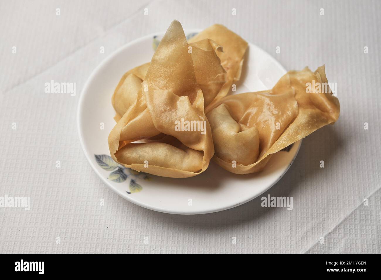 Wonton frits à New Loon Fung, sur Gerrard Street, Londres, 27 décembre 2022. Lee Shun-bun est le dernier de son genre, le seul restaurateur de sa génération d'immigrants chinois dans le quartier chinois de Londres. Il est aussi bien plus qu'un propriétaire de restaurant HHover les décennies, il est devenu le pivot de Chinatown, quelqu'un qui maintient la culture chinoise vivante par son rôle de président de la Chambre de commerce chinoise du Royaume-Uni, et à qui la communauté se tourne pour le soutien et les conseils.H27DEC22 CRÉDIT: Ming Tang-Evans Banque D'Images