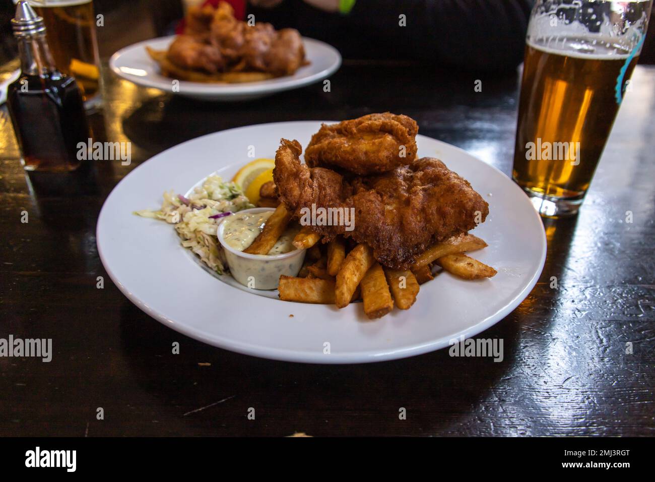 Une assiette de Fish and chips traditionnelle est servie dans le pub de style britannique. Fish and chips est un plat chaud composé de poisson frit, servi avec des frites (vendredi français Banque D'Images