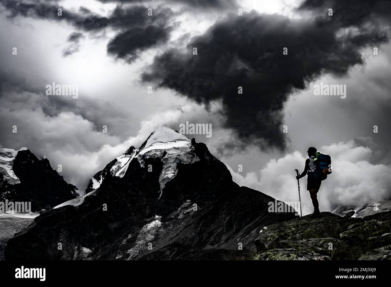 Grimpeurs devant le sommet du groupe Bernina avec des nuages dramatiques, St Moritz, Engadin, Graubuenden, Suisse Banque D'Images