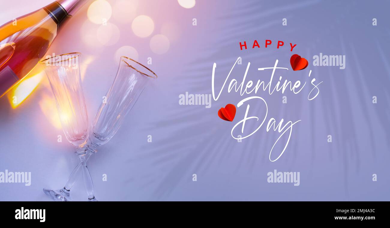 bannière ou carte de vœux Bonne Saint Valentin. Champagne et deux verres de vin sur fond rose tropical romantique. Banque D'Images