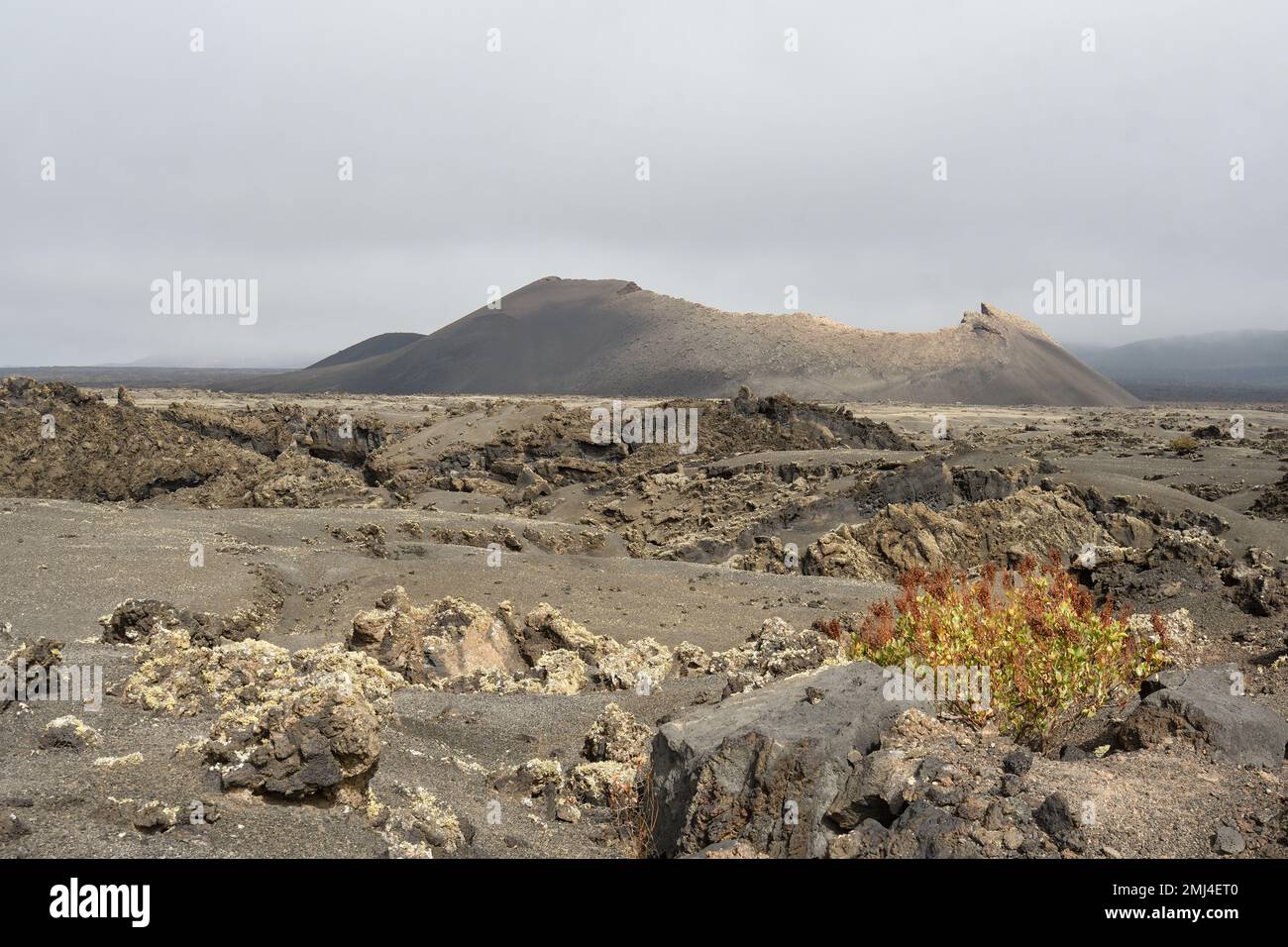 Vieux cône volcanique entouré de lave à Tinajo, Lanzarote Banque D'Images