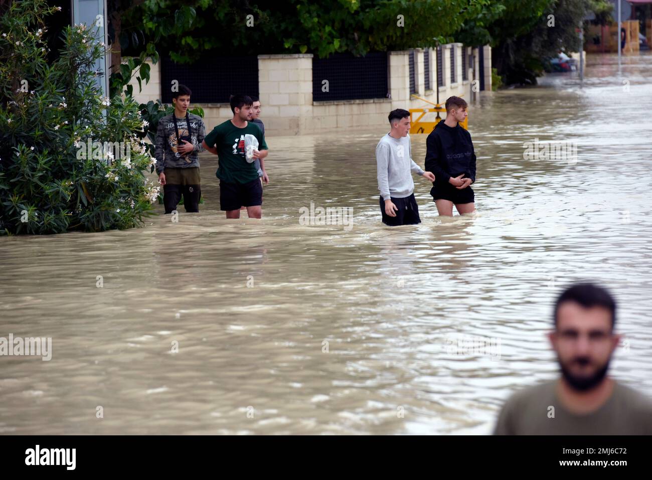 People walk along a flooded street after heavy raining in El Raal, near Murcia, Spain, Saturday, Sept. 14, 2019. Authorities say that record rainfall in southeastern Spain have claimed the lives of two more victims, taking the death toll to six from the storms that have flooded roads and towns. A sixth victim was confirmed by authorities on Saturday, a 41-year-old man in the town of Orihuela, where the river Segura overflowed its banks on Friday. (AP Photo/Alfonso Duran) Banque D'Images