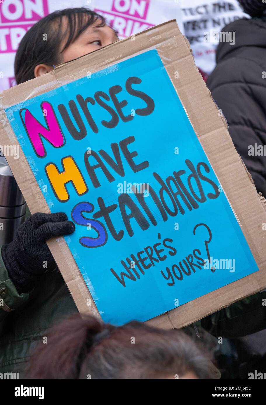 Grève des infirmières portant des panneaux, manifestant devant l'entrée de l'hôpital universitaire de Londres, pour protester contre les réductions gouvernementales et les salaires injustes. Banque D'Images
