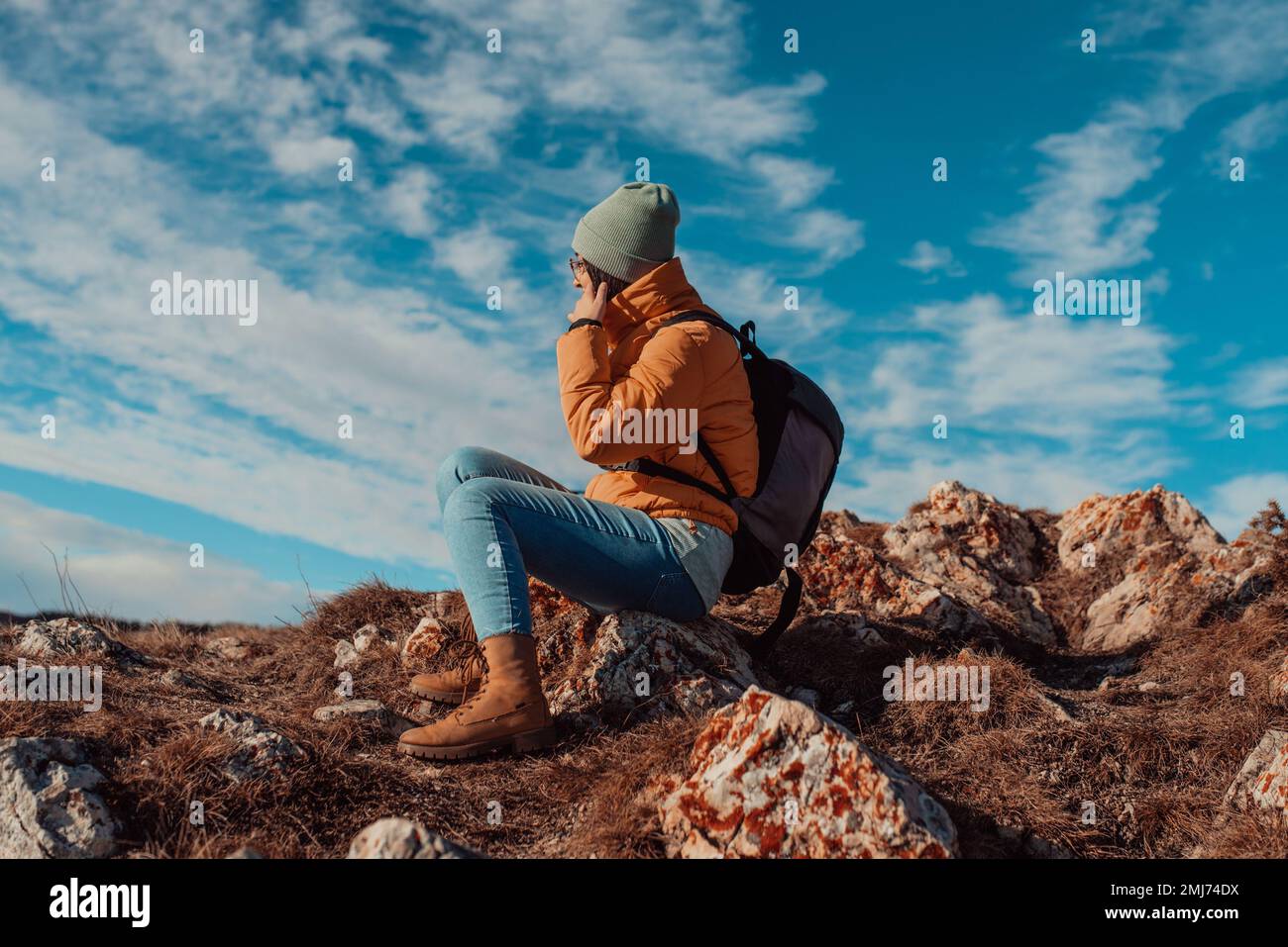 Femme voyageur libre assise au sommet des montagnes et profiter d'une nature merveilleuse. Yound Girl sur la montagne de pic avec une vue parfaite montagnes enneigées Banque D'Images